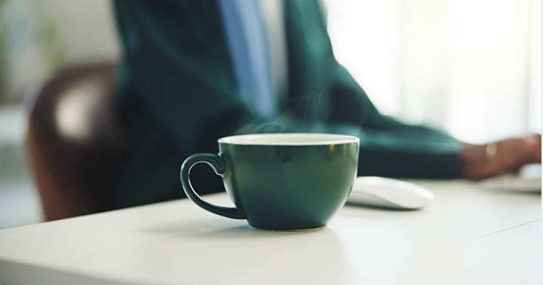 Schreibtisch, Tasse, Hintergrund arbeitende Person